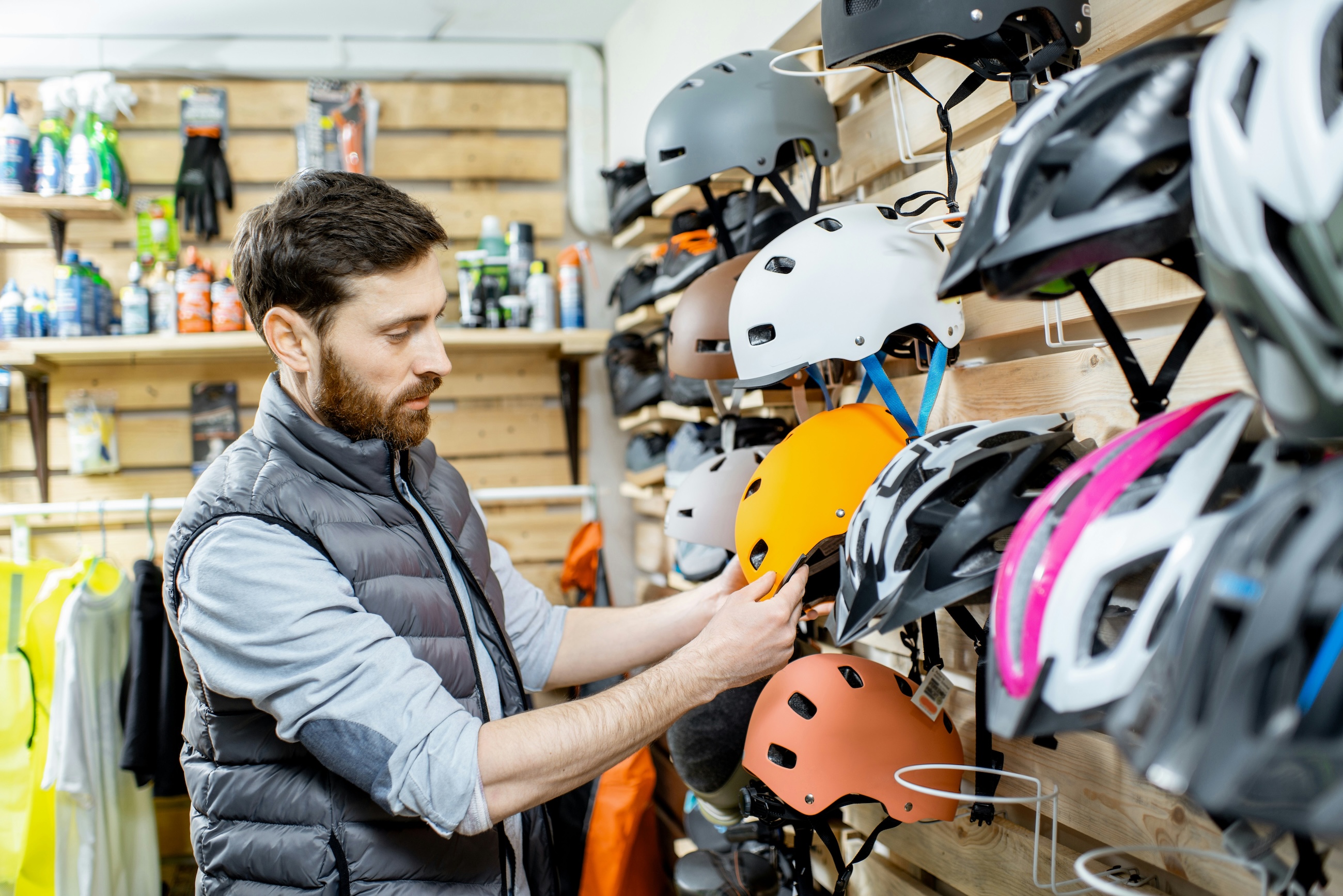 An outfitter staff member checking helmets on the wall of a gear shop